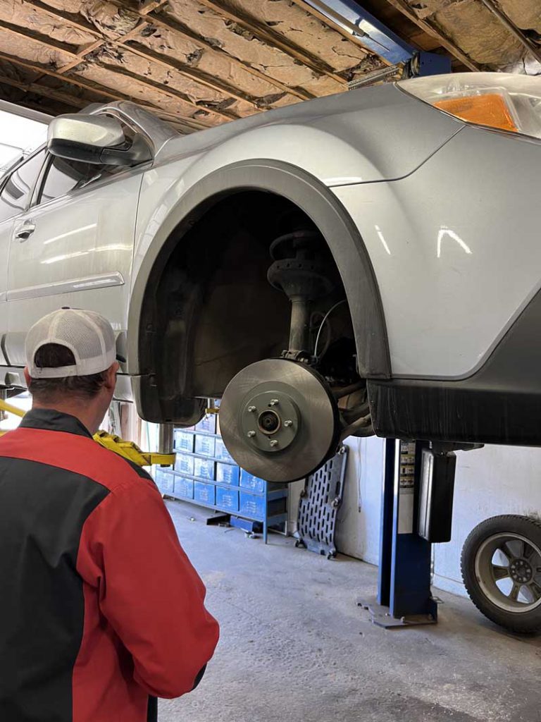 Car without wheel on lift at Durango Automotive Repair